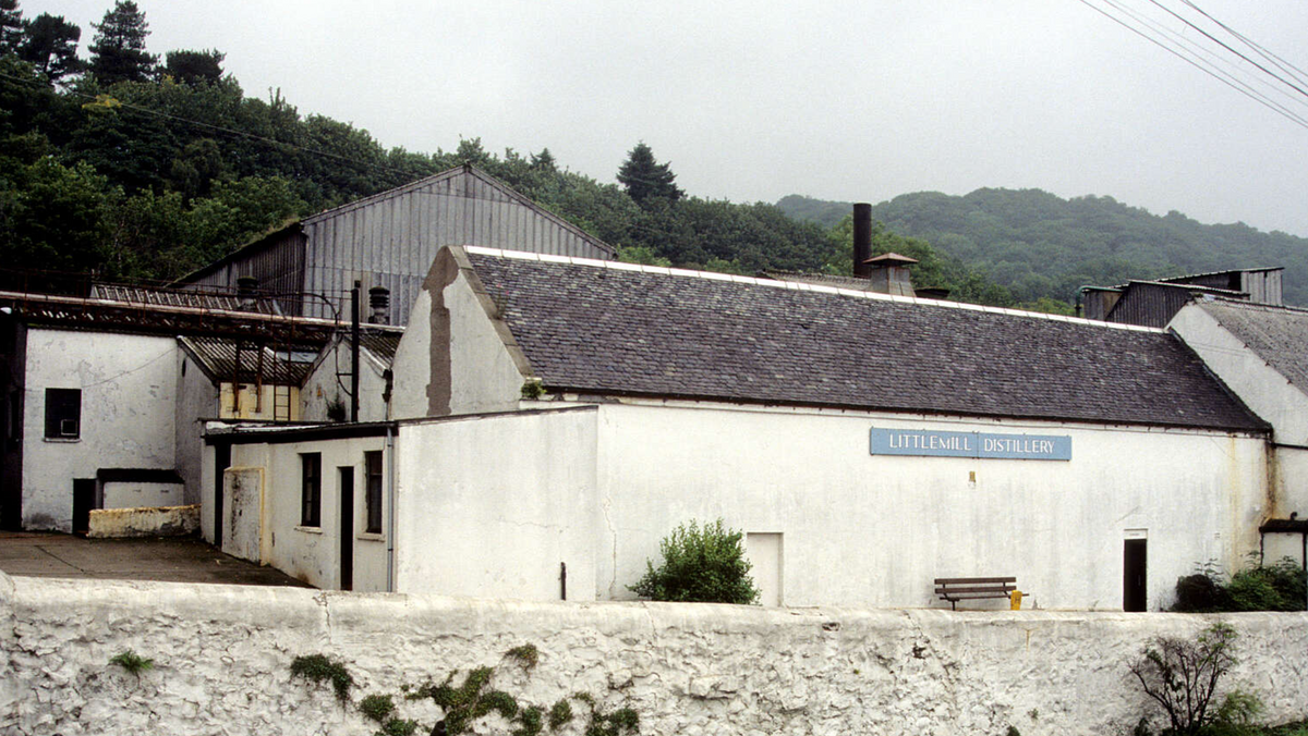 Littlemill Distillery's whitewashed buildings against a wooded hillside, with the blue Littlemill Distillery sign, before the site's demolition and 2004 fire